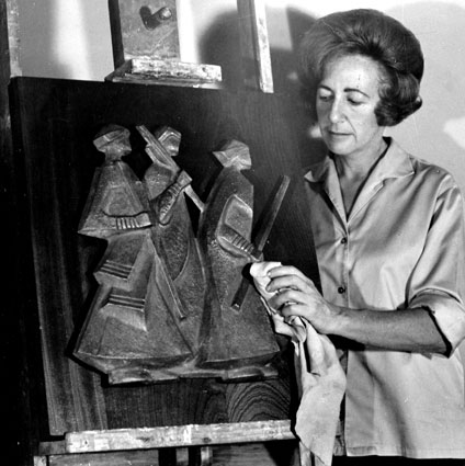 Lily SACHS applying finishing off touches to her small panel "Marching Africans" in bronze on wood